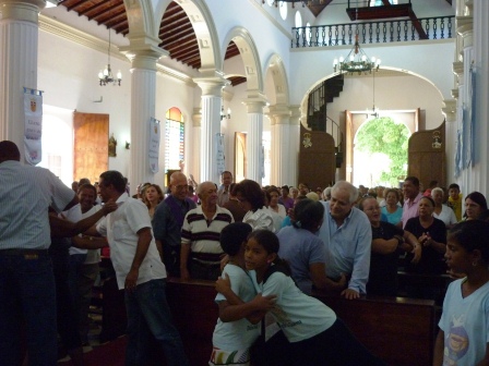 Saludo de la paz en iglesia católica. Archivo