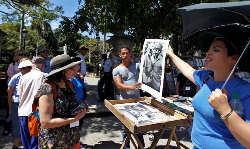 Una guía de turistas muestra una foto con la imagen de Fidel Castro junto al escritor Ernest Hemingway, en La Habana 