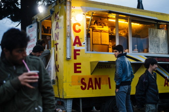 Un niño migrante permanece parado junto a un café en un campo de refugiados en la frontera greco-macedonia, cerca de Idomeni, en Grecia
