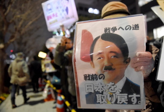 Un manifestante muestra una caricatura del primer ministro japonés, Shinzo Abe, durante una manifestación anti-nuclear en Tokio