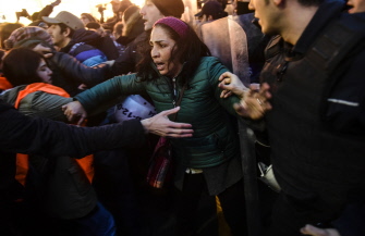 Una mujer es empujada por la policía antidisturbios en una manifestación en Estambul en memoria de las víctimas del ataque de Ankara