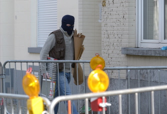 Un policía belga llega ante la casa donde tuvo lugar ayer un tiroteo durante una operación antiterrorista en Forest-Vorst, Bruselas