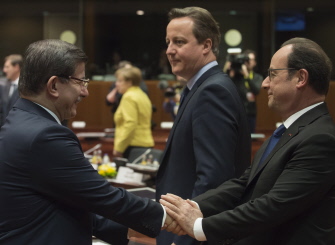 El primer ministro turco, Ahmet Davutoglu (i), saluda al presidente francés, Francois Hollande (d), durante la cumbre de Bruselas