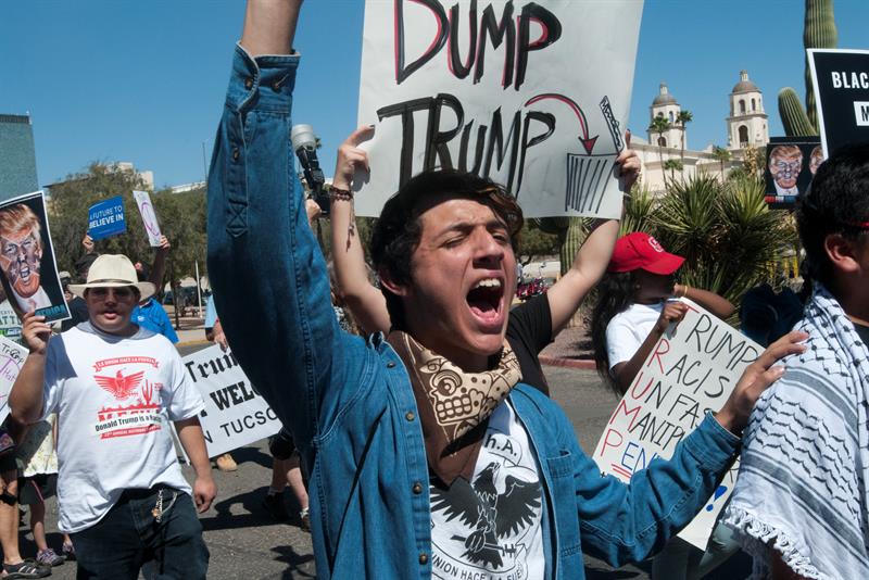 Manifestantes gritan consignas contra Donald Trump en un evento del magnate republicano en el Centro de Convenciones de Tucson, Arizona 
