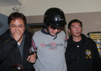 Policías taiwaneses escoltan al presunto asesino de la niña en una calle de Taipei