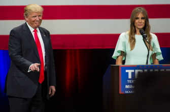 Donald Trump escucha a su mujer, Melania Trump, hablar a sus seguidores en un acto de campaña en Milwaukee, Wisconsin