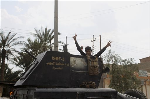 Un miembro de las fuerzas de élite antiterroristas iraquíes hace la señal de la victoria tras la toma de Hit, al oeste de Bagdad, al Estado Islámico