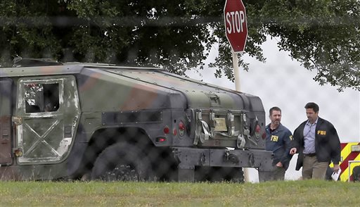 Agentes del FBI caminan junto a un vehículo militar cerca de la escena del tiroteo en la base de San Antonio-Lackland, hoy en San Antonio