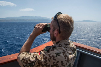 Un militar alemán que sirve en el barco Bonn, en una misión de apoyo de la OTAN, mira hacia el mar Egeo, ante la costa turca, con sus binoculares