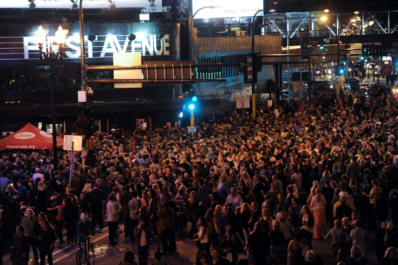 Una multitud se reúne afuera de 'First Avenue' que aparece en la película 'Purple Rain' para honrar la memoria de Prince. 