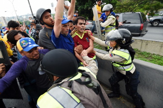 El líder opositor venezolano, Henrique Capriles (c), levanta sus brazos durante un forcejeo con la policía en la manifestación en Caracas 