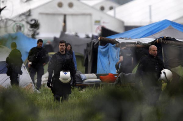 Policías griegos inspeccionan las tiendas de campaña en un campamento de refugiados improvisado en la frontera entre Grecia y Macedonia, cerca del pue