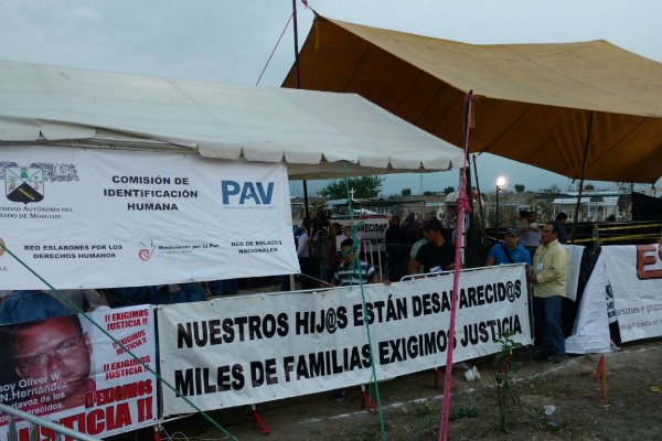 Familiares de desaparecidos permanecen cerca de la fosa de Tetelcingo, donde desde hace tres días se exhuman 116 cuerpos enterrados ahí irregularmente