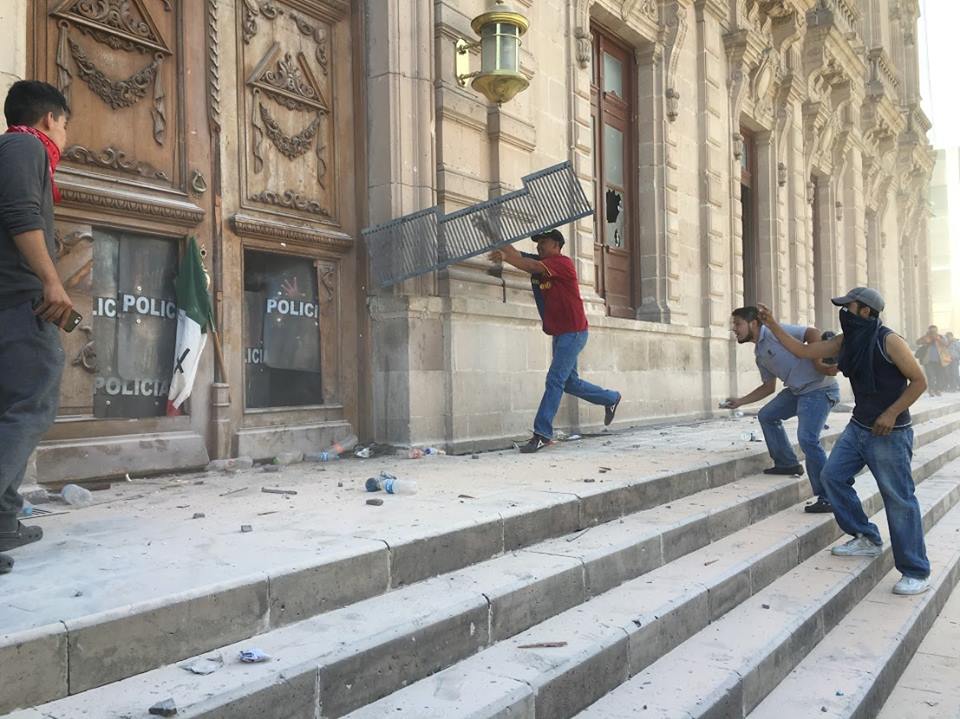 Los manifestantes rompieron vidrios y derribaron la puerta trasera del Palacio de Gobierno de Chihuahua. 