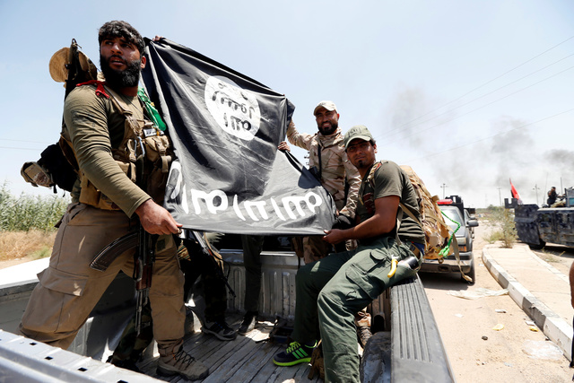 Combatientes sostienen bandera del Estado Islámico 