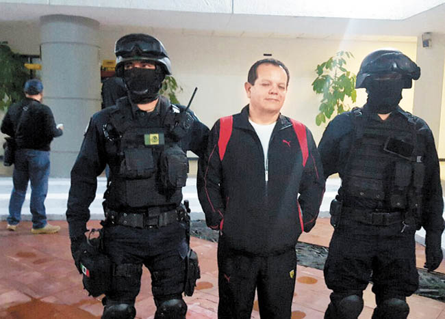 Nicandro Barrera Medrano es escoltado por dos federales en su trasladado al penal del Altiplano. 