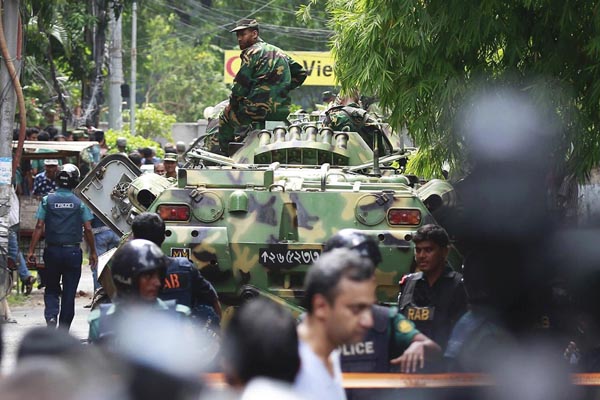 Soldados y personal de seguridad acordonan una zona cercana al restaurante popular entre los extranjeros después de que militantes armados tomaron dec