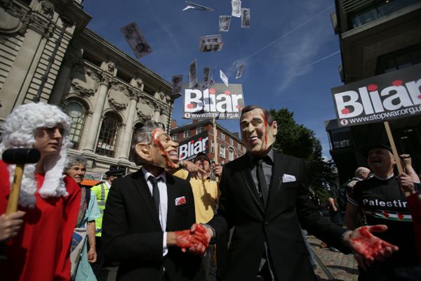 Manifestantes con mascaras del ex presidente estadunidense, George W. Bush, y del ex primer ministro británico, Tony Blair, piden la realización de un