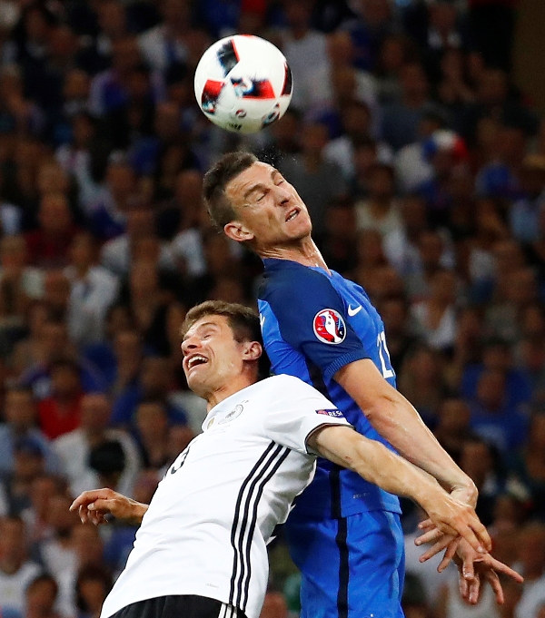 Thomas Muller y  Koscielny se juegan un balón aéreo 