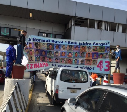 Los manifestantes portan pancartas con las fotografías de los jóvenes desaparecidos en Iguala en 2014.