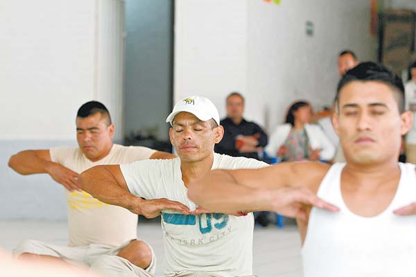 Presos del Reclusorio Norte hacen ejercicios de respiración.