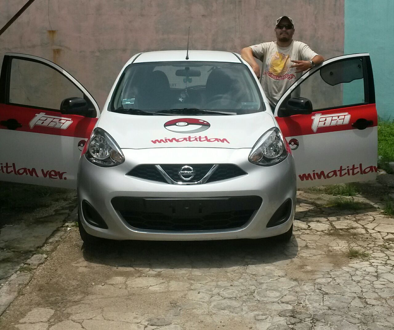 Emilio y su taxi con calcomanía de Pokébola.