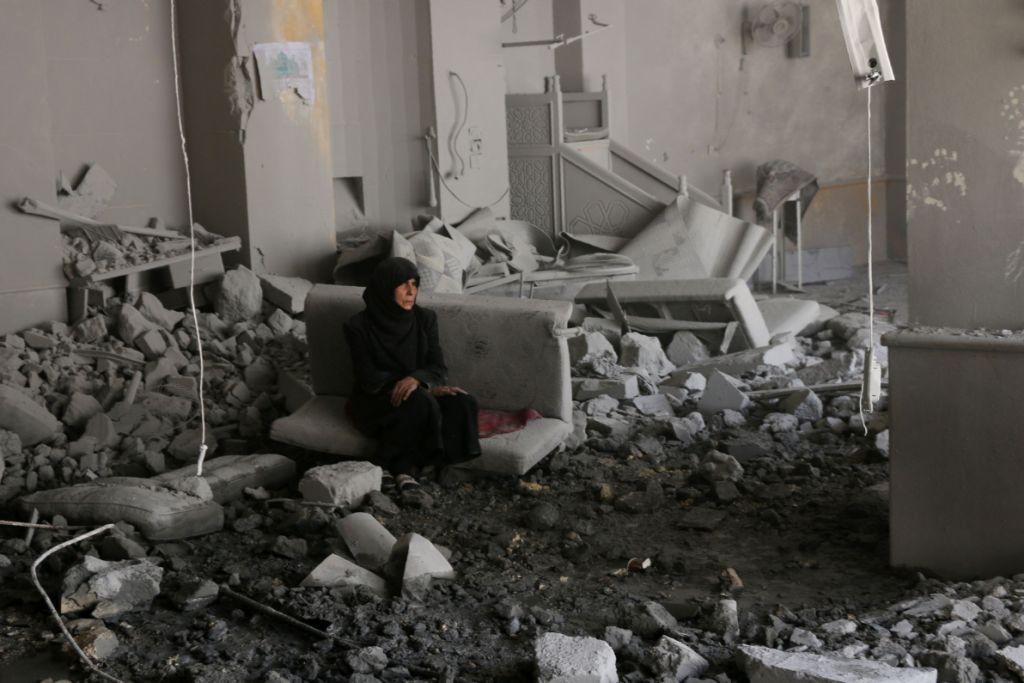 Mujer siria entre los escombros de un edificio después de un ataque en el barrio de Alepo.