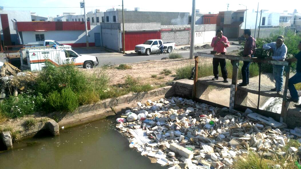 En la colonia Los Álamos de Gómez Palacio, la basura en el canal de riego provocó un desborde del agua.