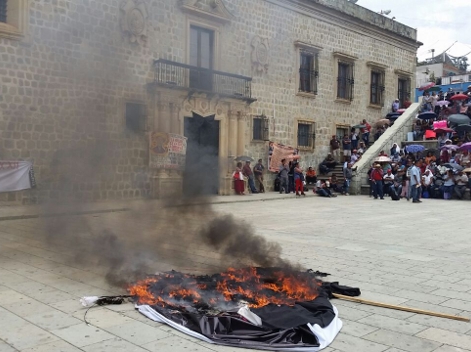 Encapuchados descolgaron espectaculares que se encontraba en la fachada del inmueble para romperlos y quemarlos.