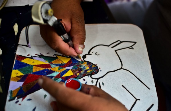 Los diseñadores utilizan máquinas improvisadas de tatuajes para darle vida a las pieles que harán las bolsas. 