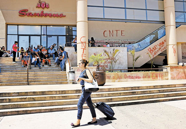 Disidentes pintaron consignas en la fachada de una plaza comercial en la capital chiapaneca. 
