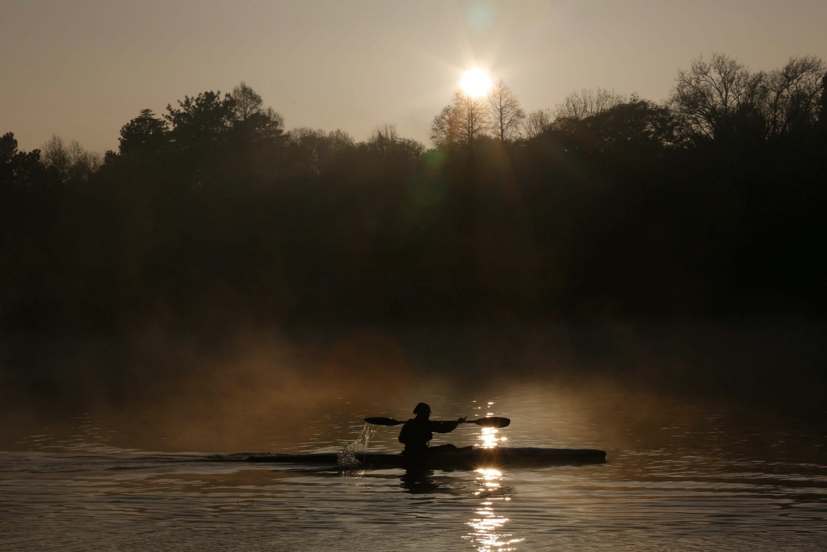 Un hombre rema sobre una canoa durante una mañana de invierno en la presa de Emmarencia, Johannesburgo.