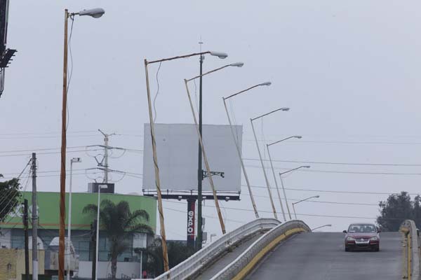 En el puente elevado de la avenida Mariano Otero y Anillo Periférico de las lámparas cuelgan los cables por fuera y enredados en el poste.