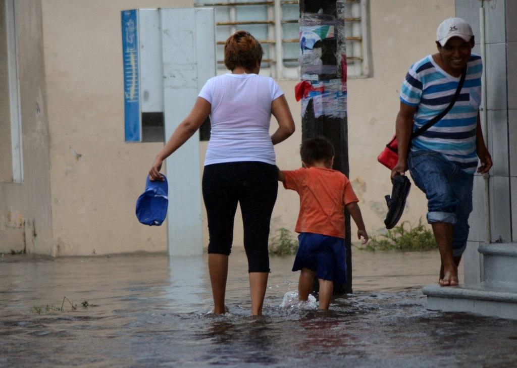 Habitantes del puerto de Veracruz caminan por las calles inundadas debido a los efectos de la tormenta tropical 'Earl'.