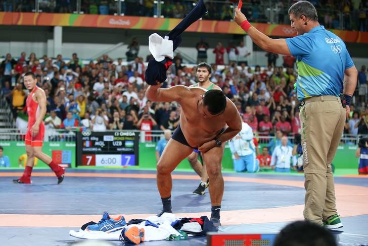 Furiosos entrenadores de luchador mongol se desvisten en protesta tras perder medalla de bronce