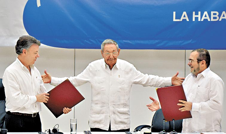 El presidente cubano (centro) y las partes firmantes.