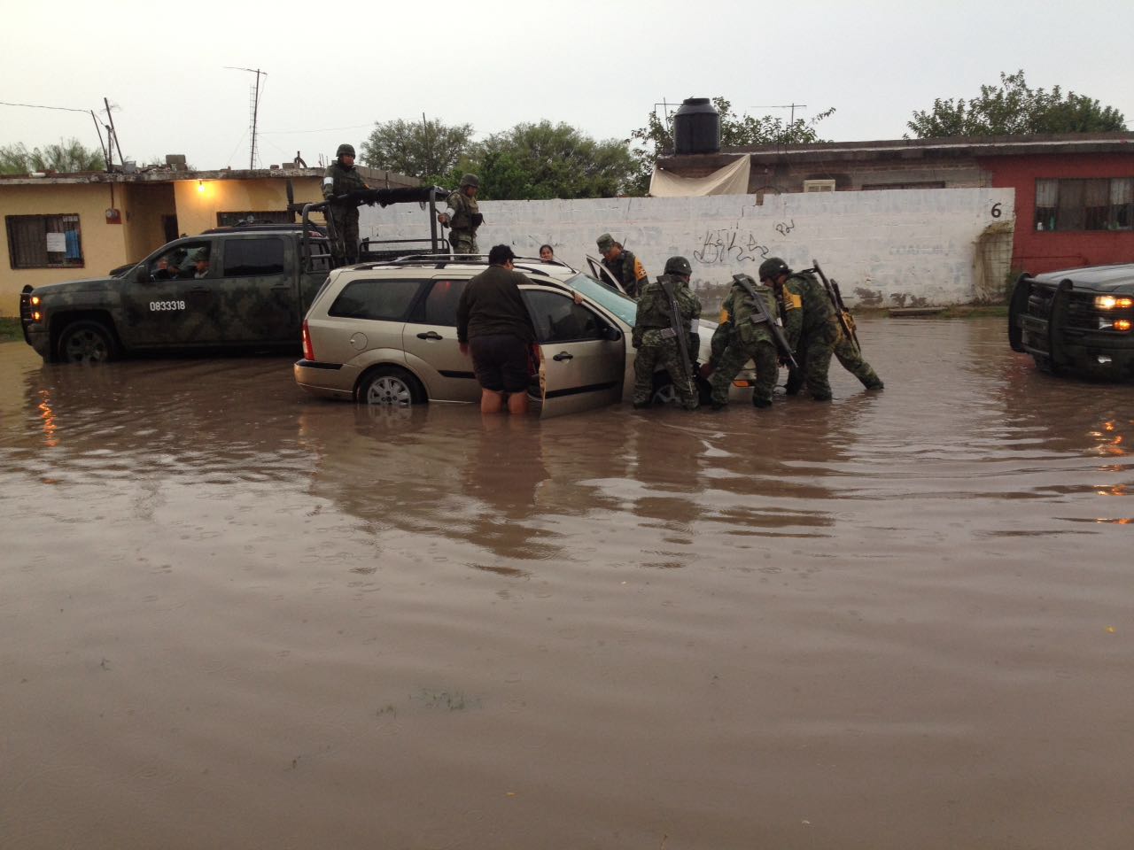 Elementos del 33 Batallón de la Sedena en apoyo a la población para sacar autos varados por la inundación.