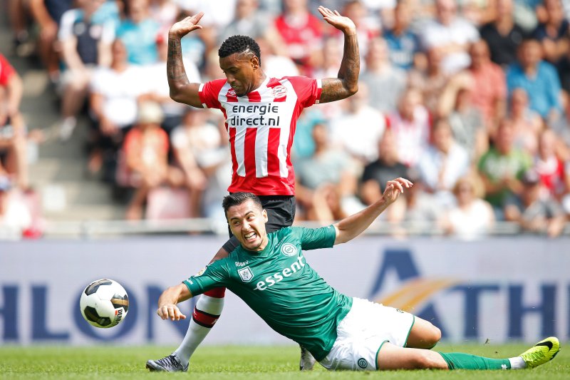 Futbolistas del PSV y Groningen disputan la pelota en el empate a cero.