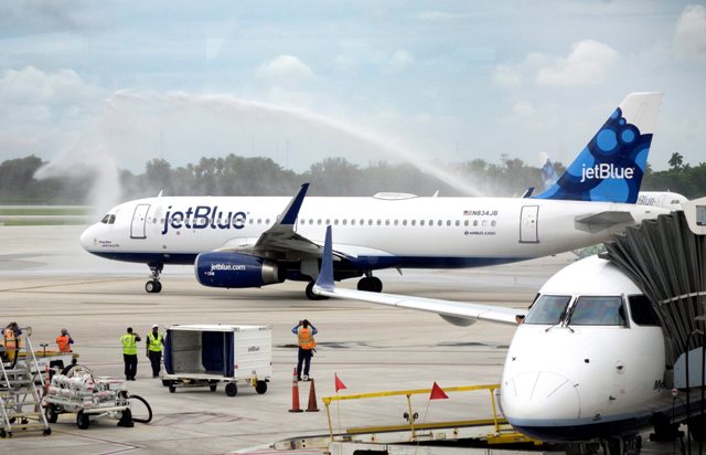 Vista del vuelo 387 de JetBlue bajo un arco de chorros de agua en la pista del Aeropuerto Internacional de Fort Lauderdale, Florida, Estados Unidos.