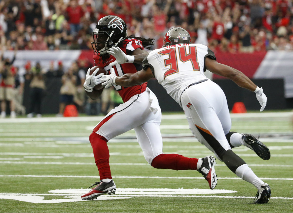 Desmond Trufant acarrea el balón ante la marca de Charles Sims.