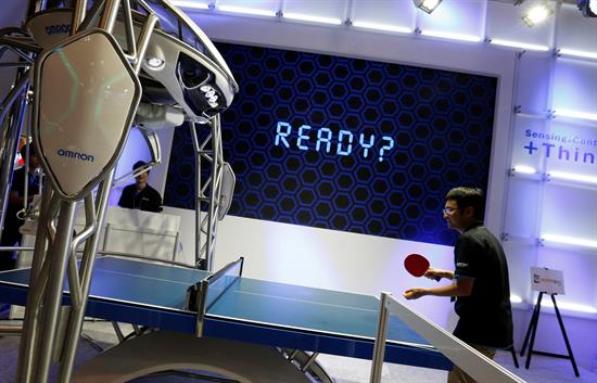 Un hombre juega con el primer robot instructor de tenis de mesa del mundo, FORPHEUS, capaz de evaluar el nivel de su contrincante y adaptar su modo de