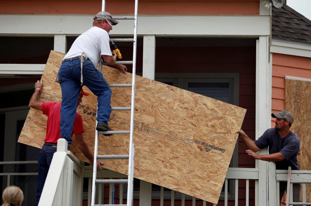 En Estados Unidos, las personas cubren sus casas para protegerlas de los fuertes vientos de 'Matthew'.