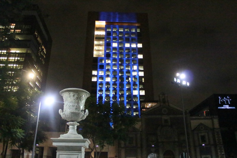 Desde la Alameda Central se puede observar el edificio de la Cancillería -que es color ocre- iluminado con luces azules.