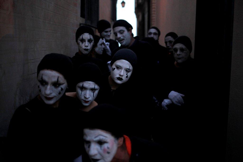 Personas disfrazadas de mimos participaron en un performance durante una protesta a favor de los refugiados en el centro de Malaga. 