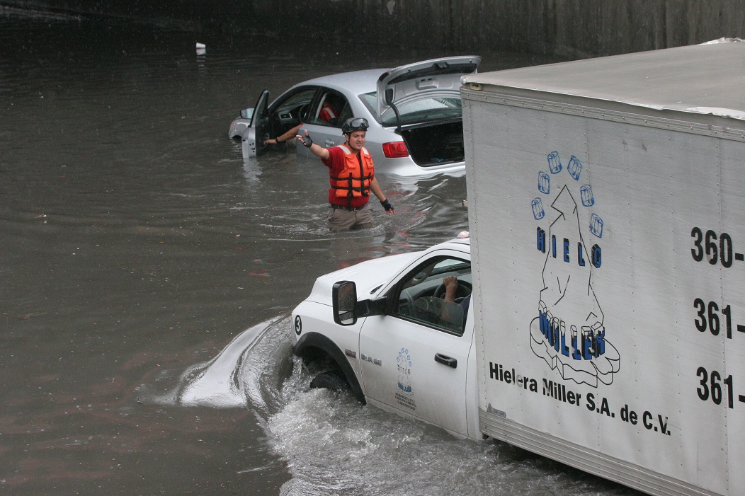 Un camión que transporta hielo logró cruzar la inundada vialidad.