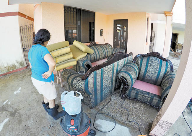 Una mujer en Tampico observa los daños a su vivienda. 