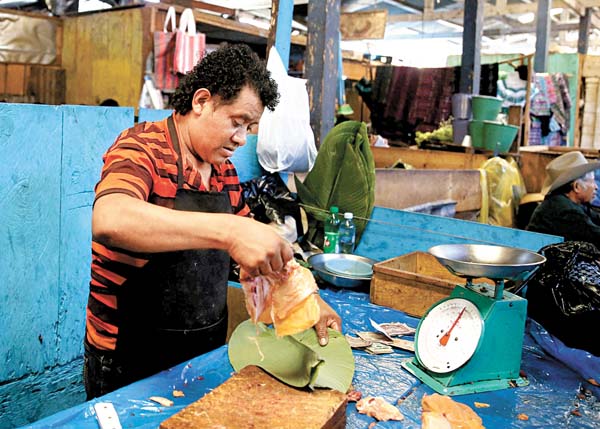 Fernando, un carnicero tzutujil que trabaja en el mercado local.