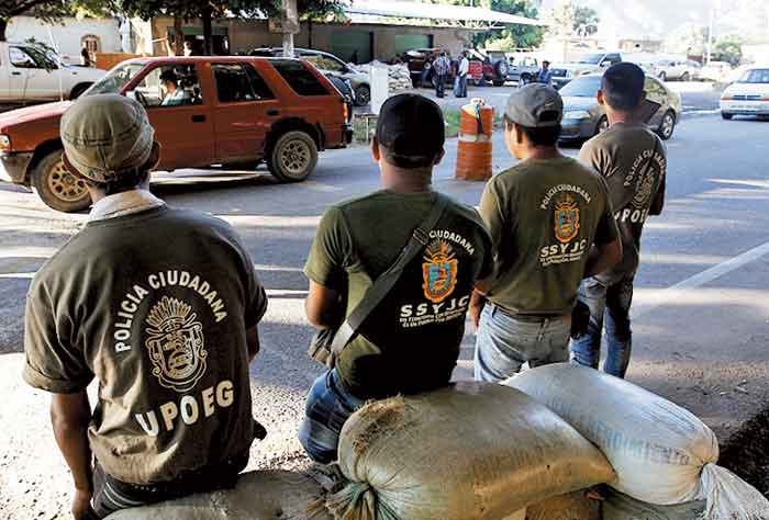 Integrantes de la Upoeg vigilan un retén.