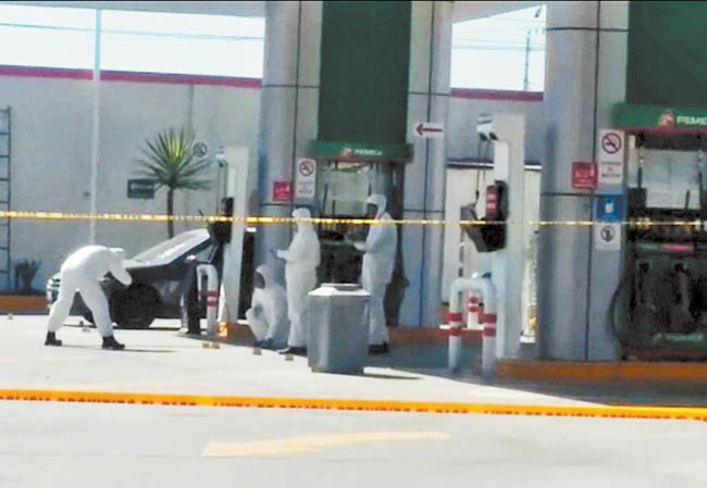 Peritos revisan la gasolinera donde fue abatido el director de la corporación municipal de Pedro Escobedo. 