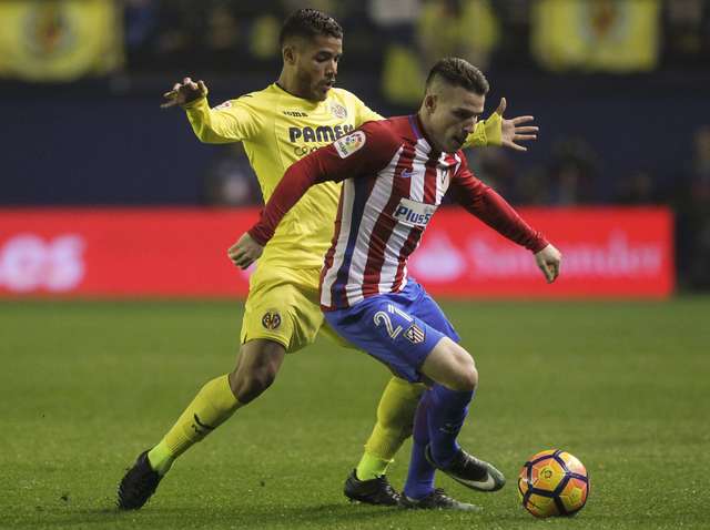 Jonathan dos Santos disputando el balón ante el defensa del Atlético.